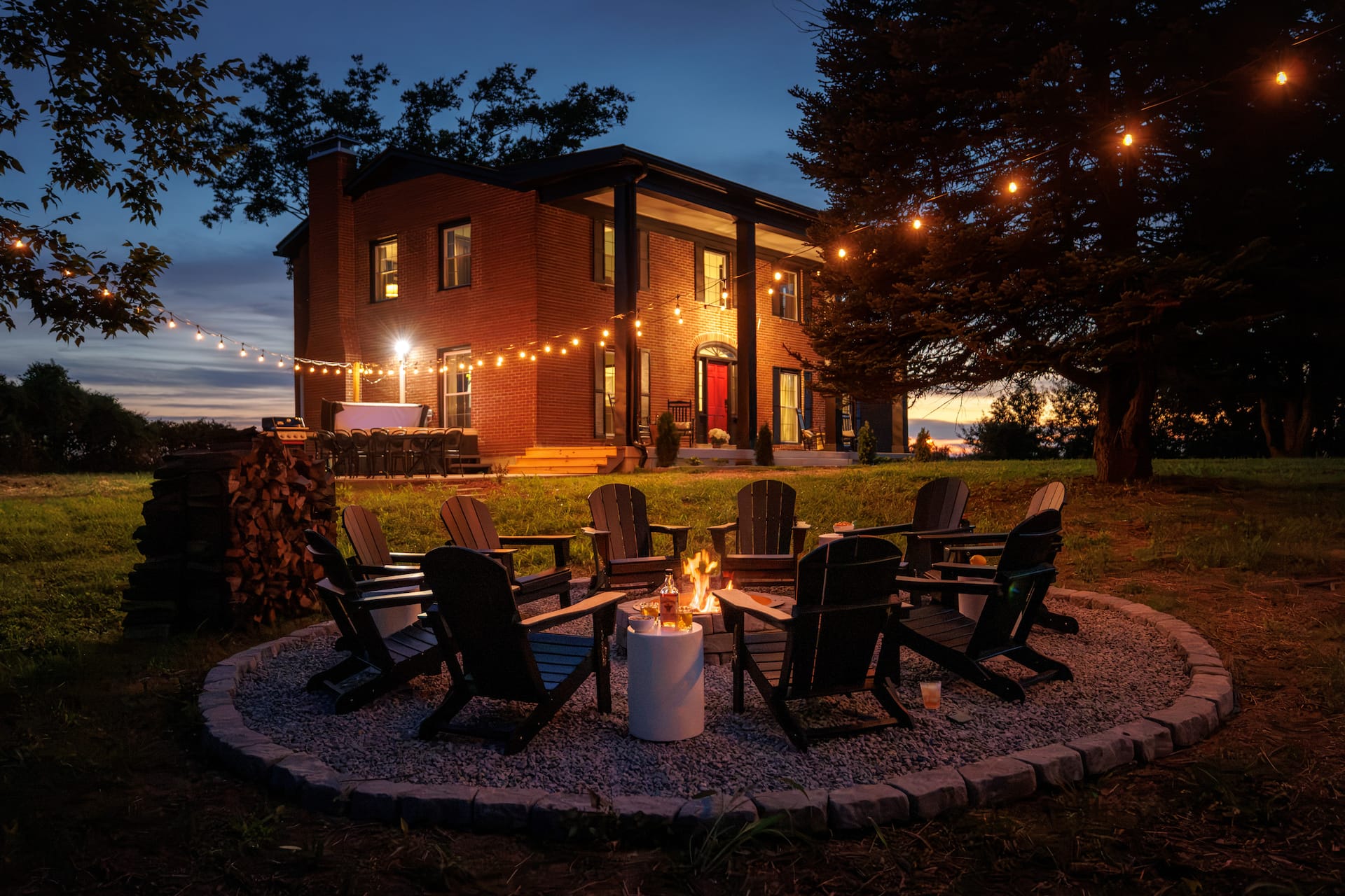 The Distiller's Estate glowing at dusk beyond a fire pit