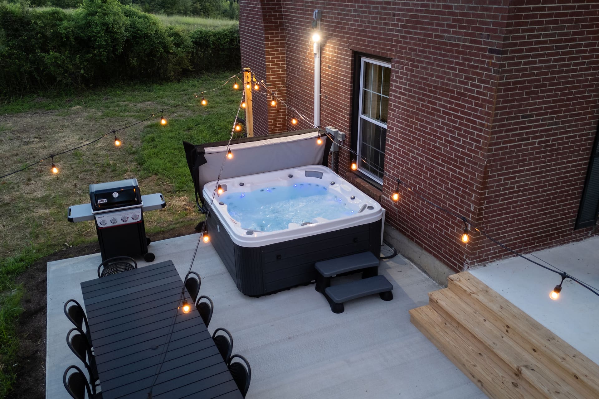 Private hot tub under outdoor string lights