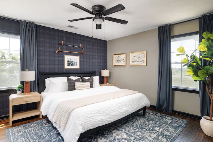 King bedroom with a deep charcoal feature wall and tailored decor